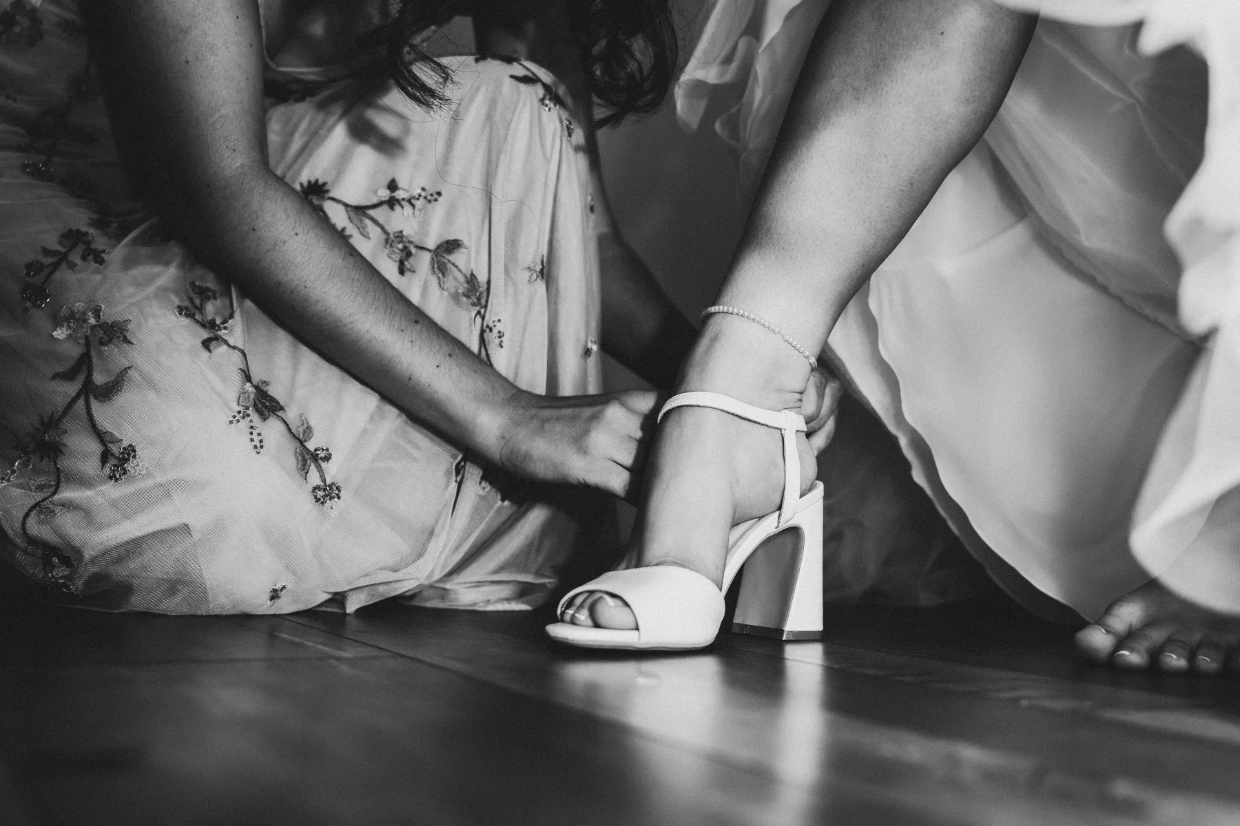 Hilfe beim Anziehen der Brautschuhe.