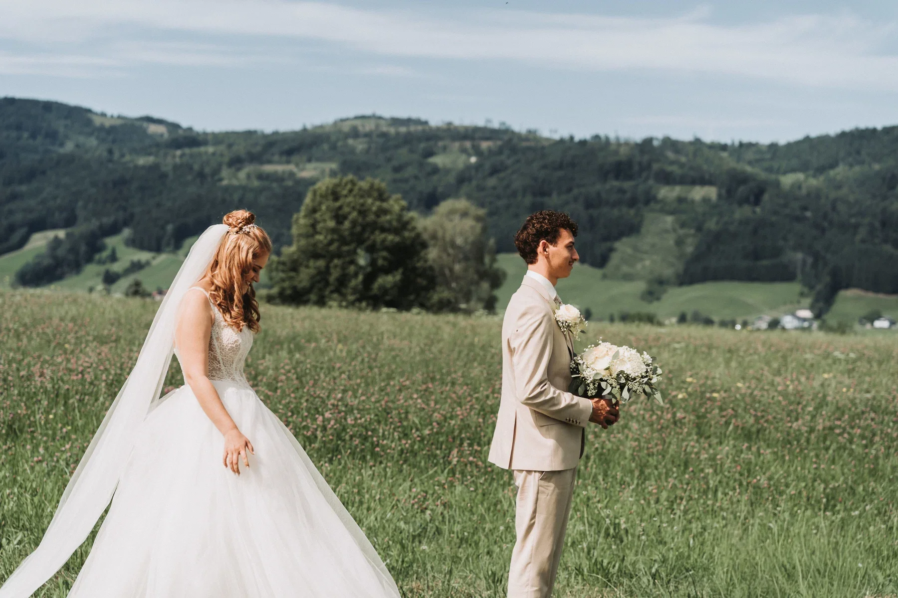 Die Braut nähert sich dem Bräutigam beim First Look.