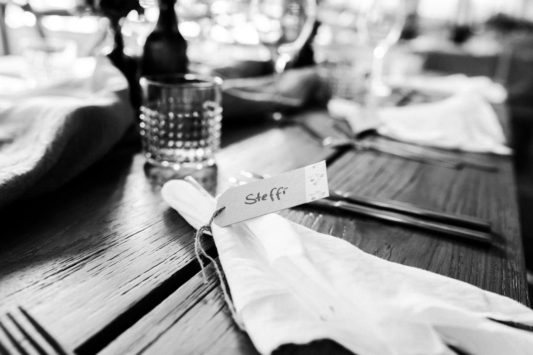 Platzkarte, Stoffserviette und Gläser in Schwarz-Weiß.