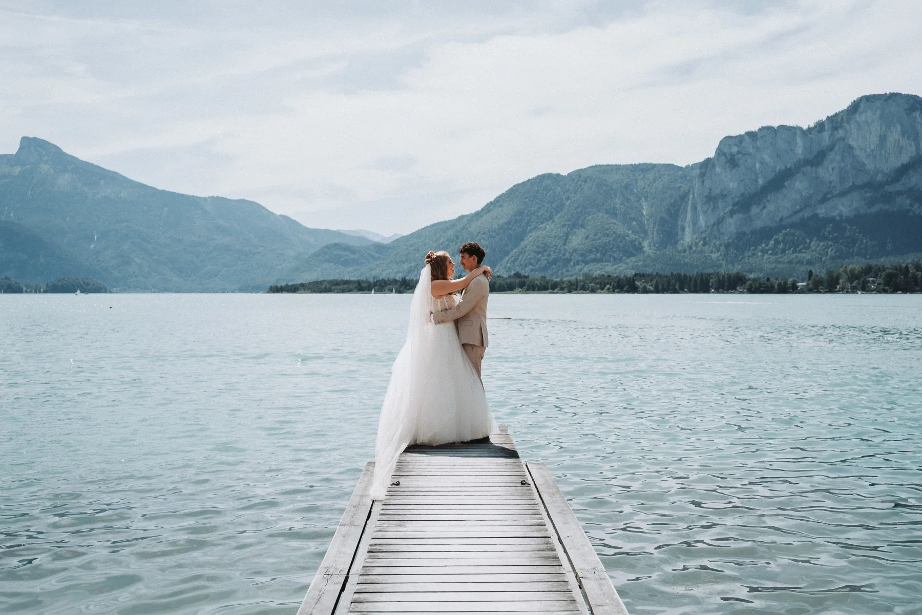 Brautpaar in einer Umarmung auf dem Steg am Mondsee.