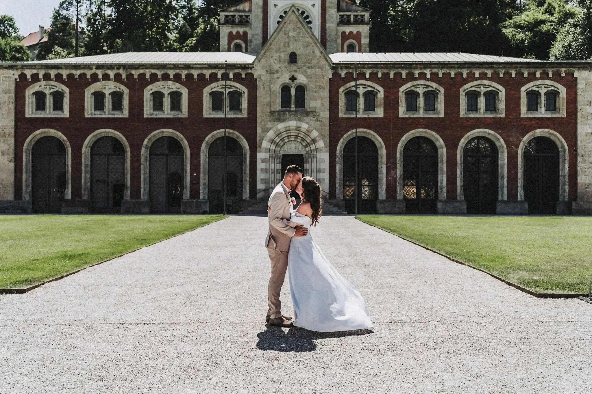 Brautpaar beim Tanzen vor einer historischen Kirche bei einer Hochzeit in Salzburg. Obi Shenouda Fotografie Salzburg.