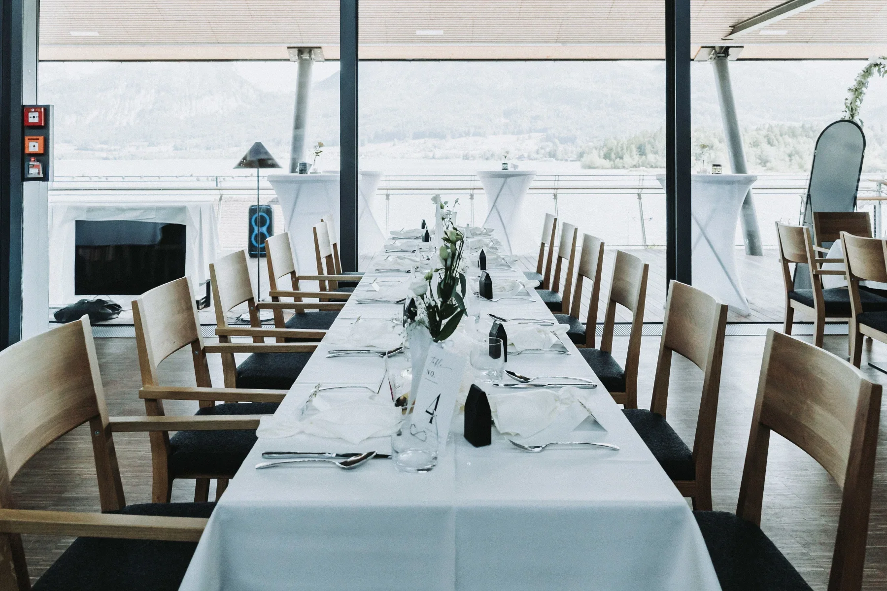 Lange Hochzeitstafel mit Tageslicht und Blick nach draußen.