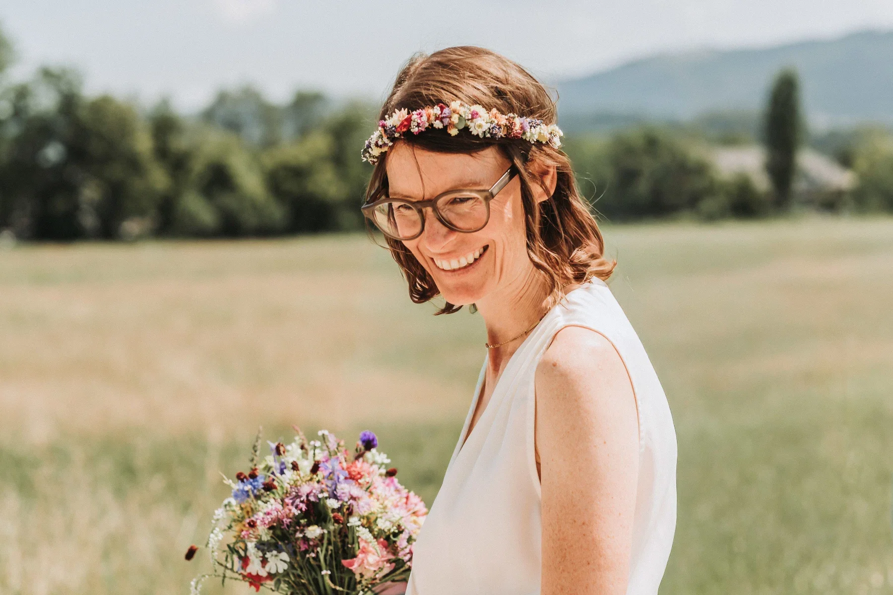 Steffi mit Brautstrauß auf einer Wiese – Hochzeit in Seekirchen am Wallersee.