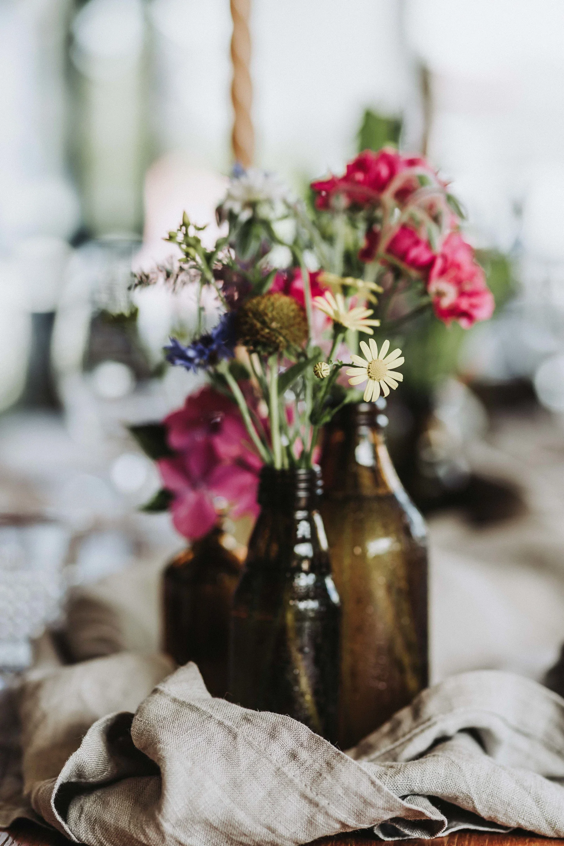 Blumenschmuck in kleinen Vasen auf dem Hochzeitstisch.