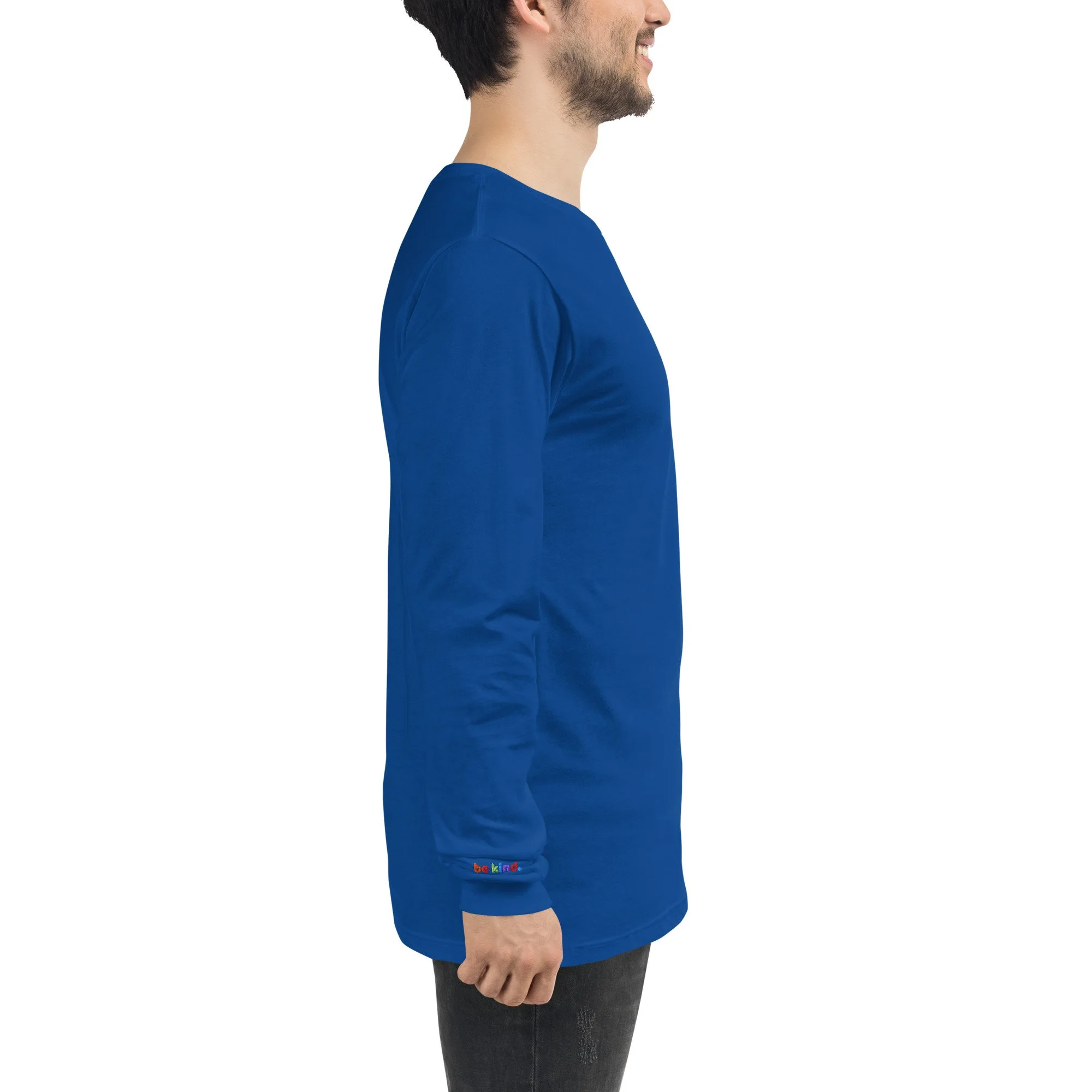 Man wearing a true royal blue be kind long sleeve tee, rainbow embroidery at his right wrist
