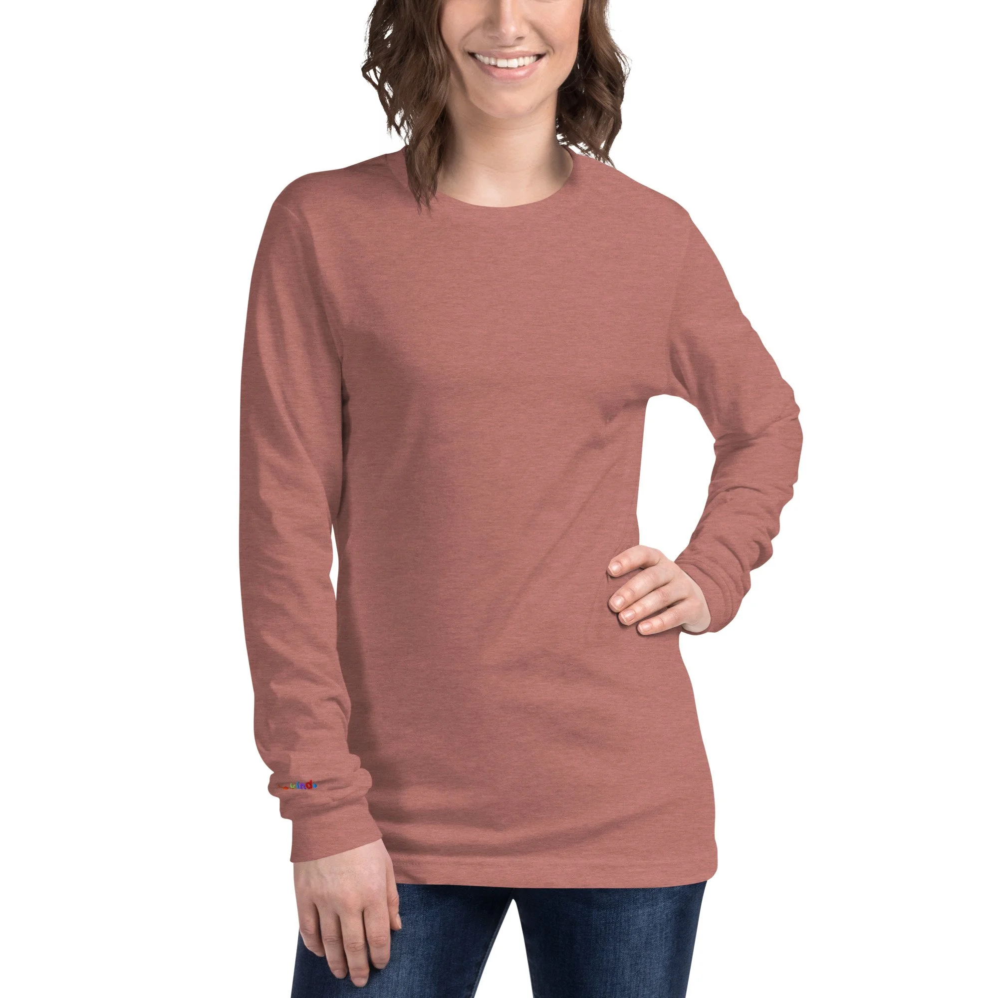 Woman wearing a heather mauve be kind long sleeve tee with the rainbow embroidery at her right wrist