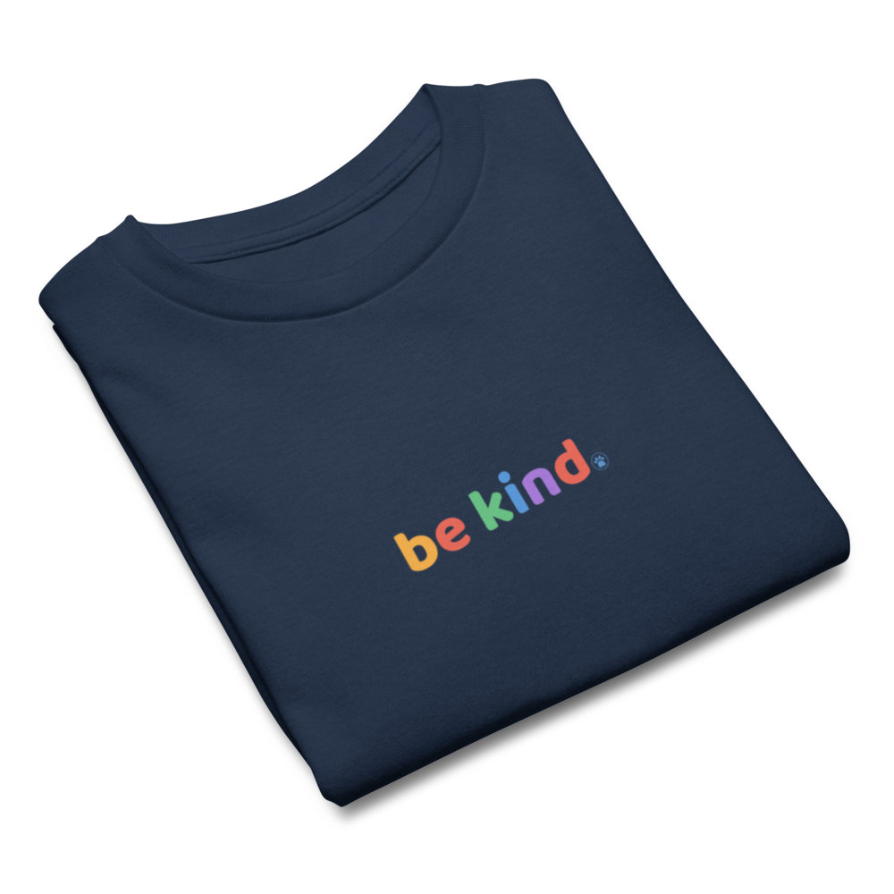 Navy kids' t-shirt folded to show the rainbow be kind print on the chest
