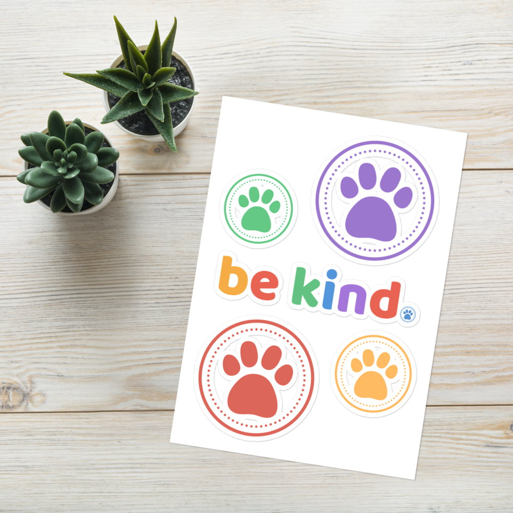 The be kind sticker sheet on white wood next to two small potted succulents