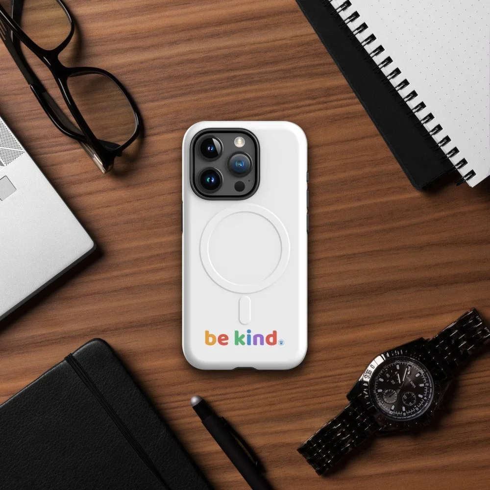 Be Kind MagSafe iPhone 15 Pro case on a wood desk with glasses, a notebook and a watch