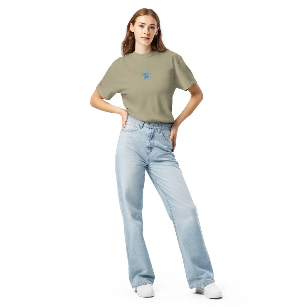 Woman wearing an olive heavyweight tee with the blue paw print on the chest