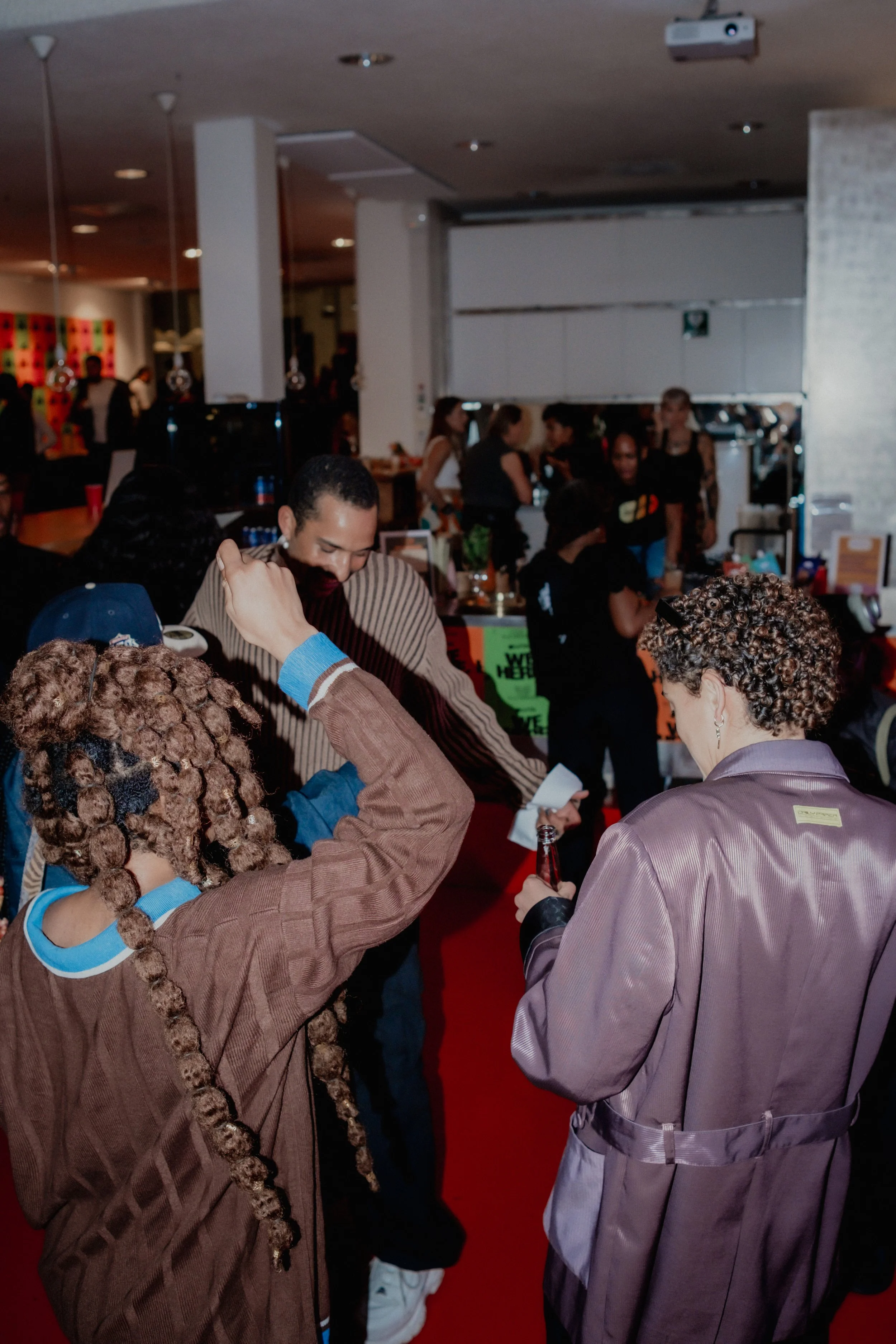 People gathered in an indoor setting, possibly a party or event, engaging in conversations and socializing.