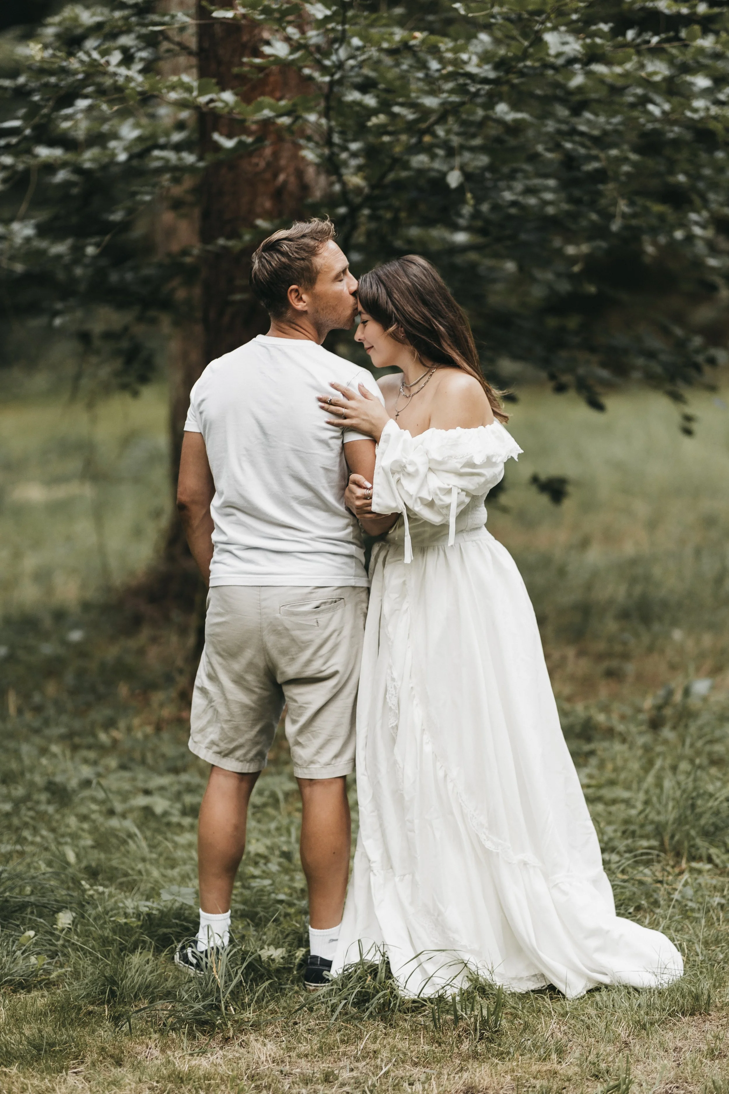 Ein Mann und eine Frau in einem Wald schließen sich liebevoll an.