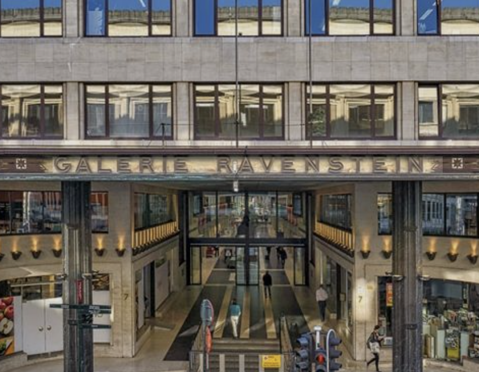 De ingang van Galerie Ravenstein in een winkelcentrum in Nederland met mensen die binnen en buiten wandelen.