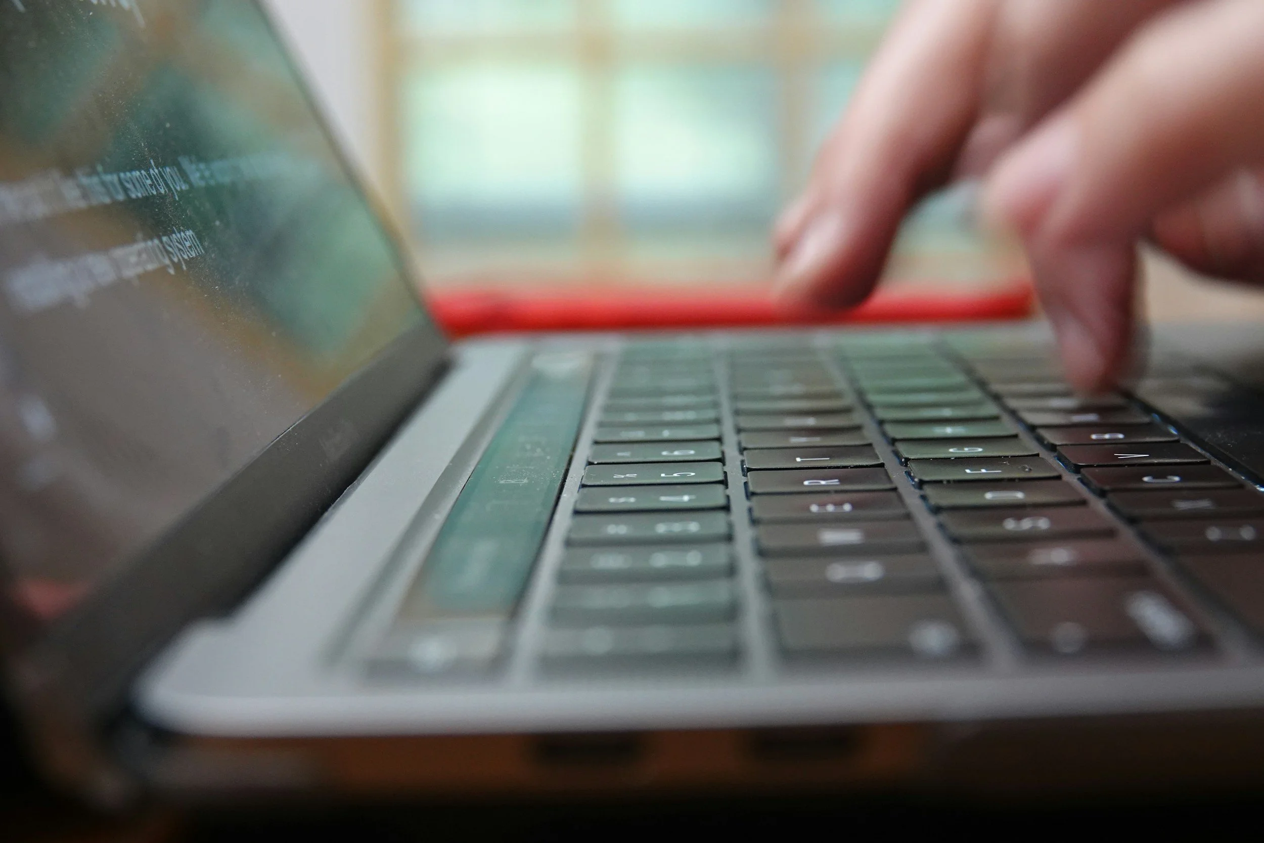 Person's hands typing a report on a laptop