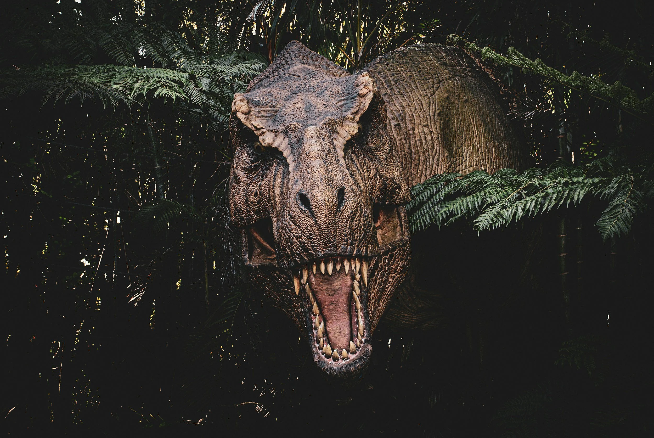 Dinosaur roaring as it emerges from the jungle