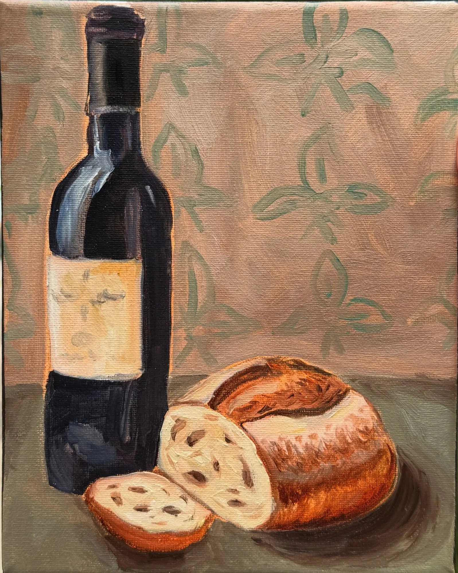 Bread and Wine, Oil paint on canvas, 8"x10" 2025. A painting on a canvas with a red wine bottle and loaf of sourdough, with a background of green leaf patterns.