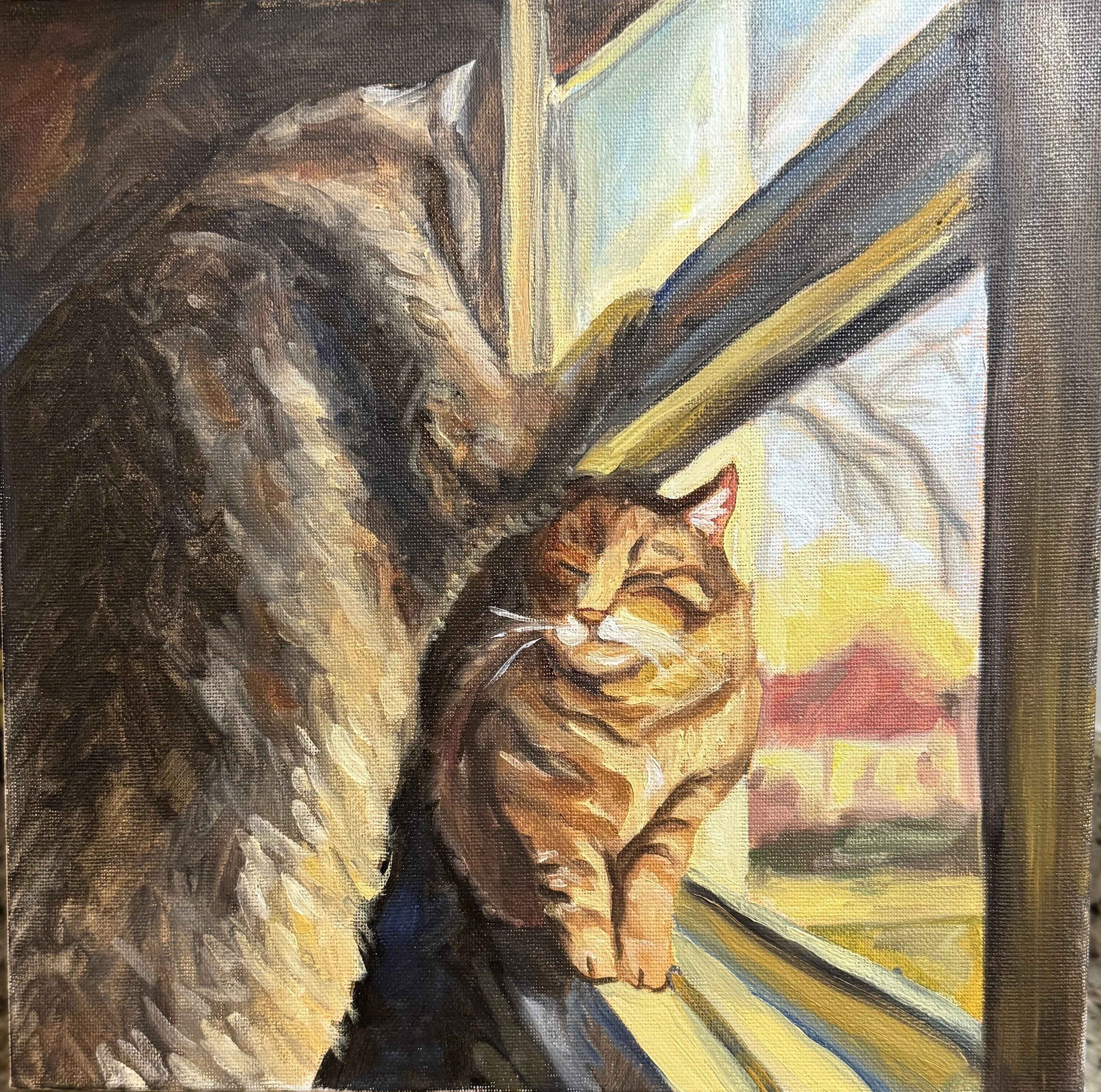 2 cats playing in a window sill.