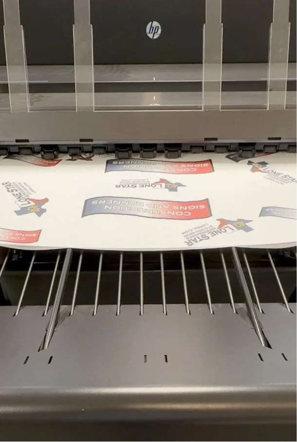 Printing press printing paper with logos and text, including 'Long Stays' and 'Consultation, Signs and Folders'.