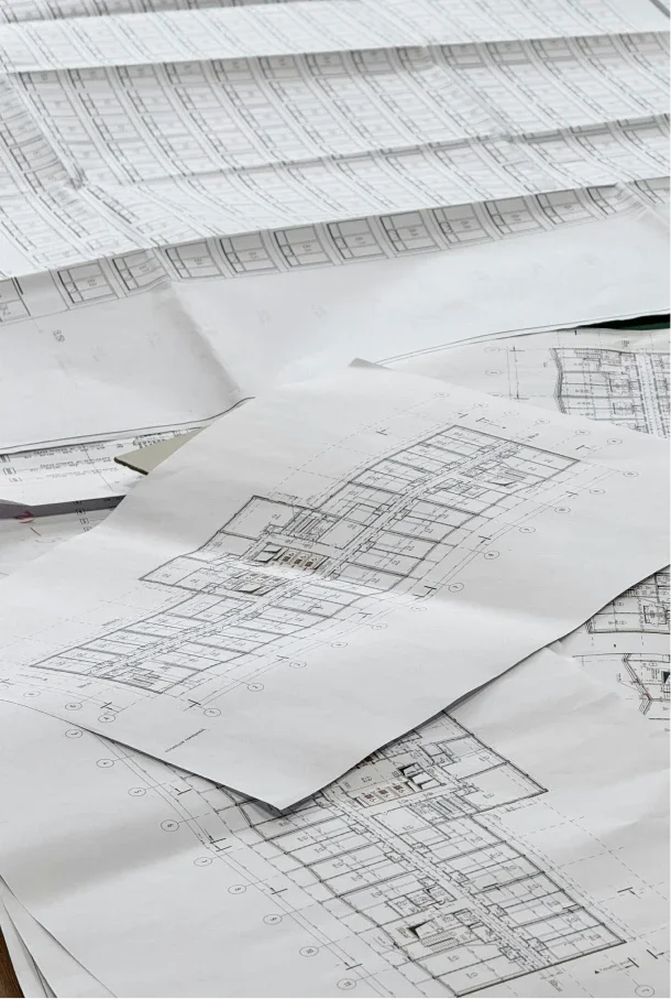 Architectural blueprints and construction plans spread out on a table.