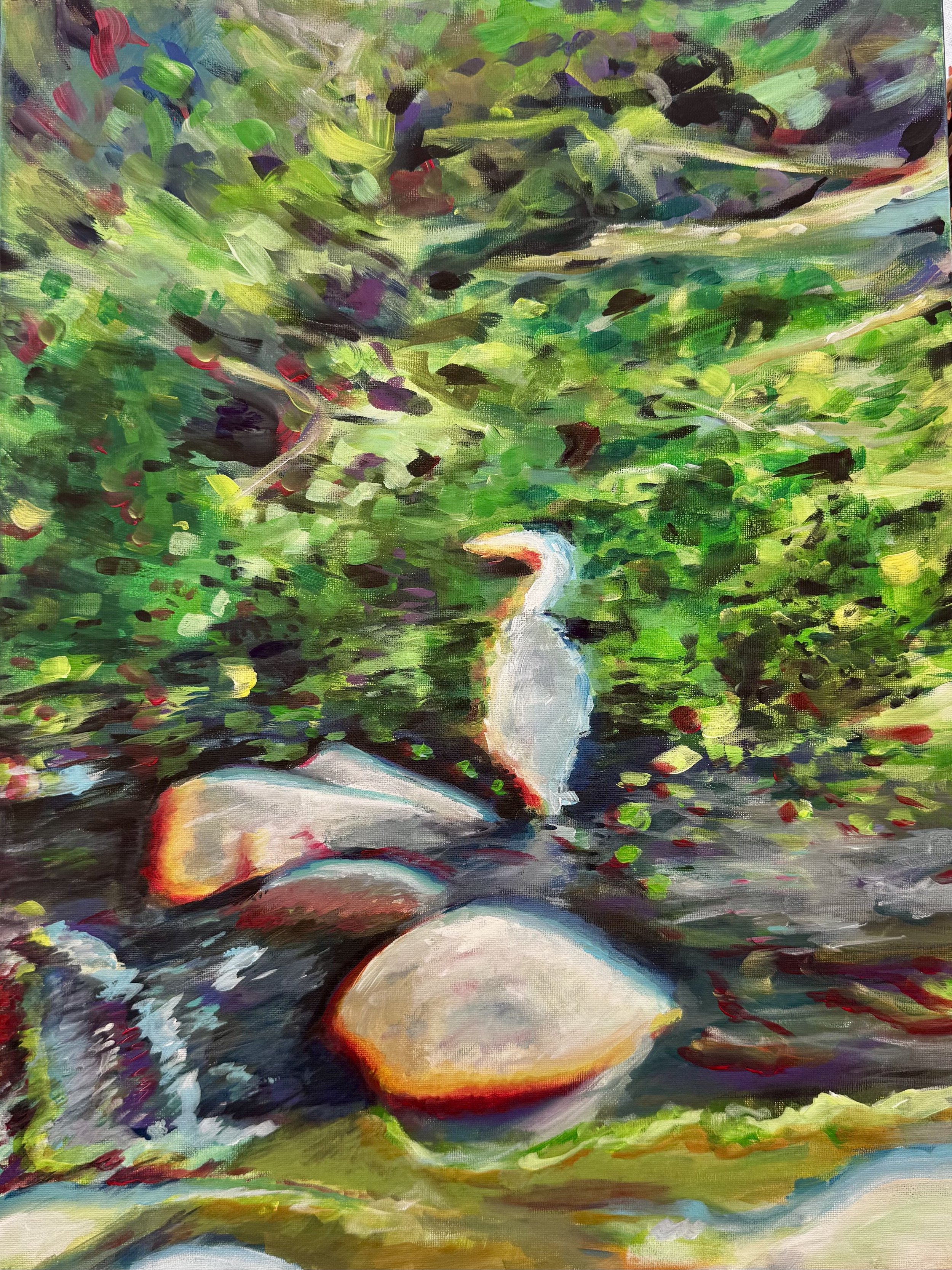A colorful impressionist-style painting of a heron by the LA River, by lush green foliage and rocks and reflections in the water.