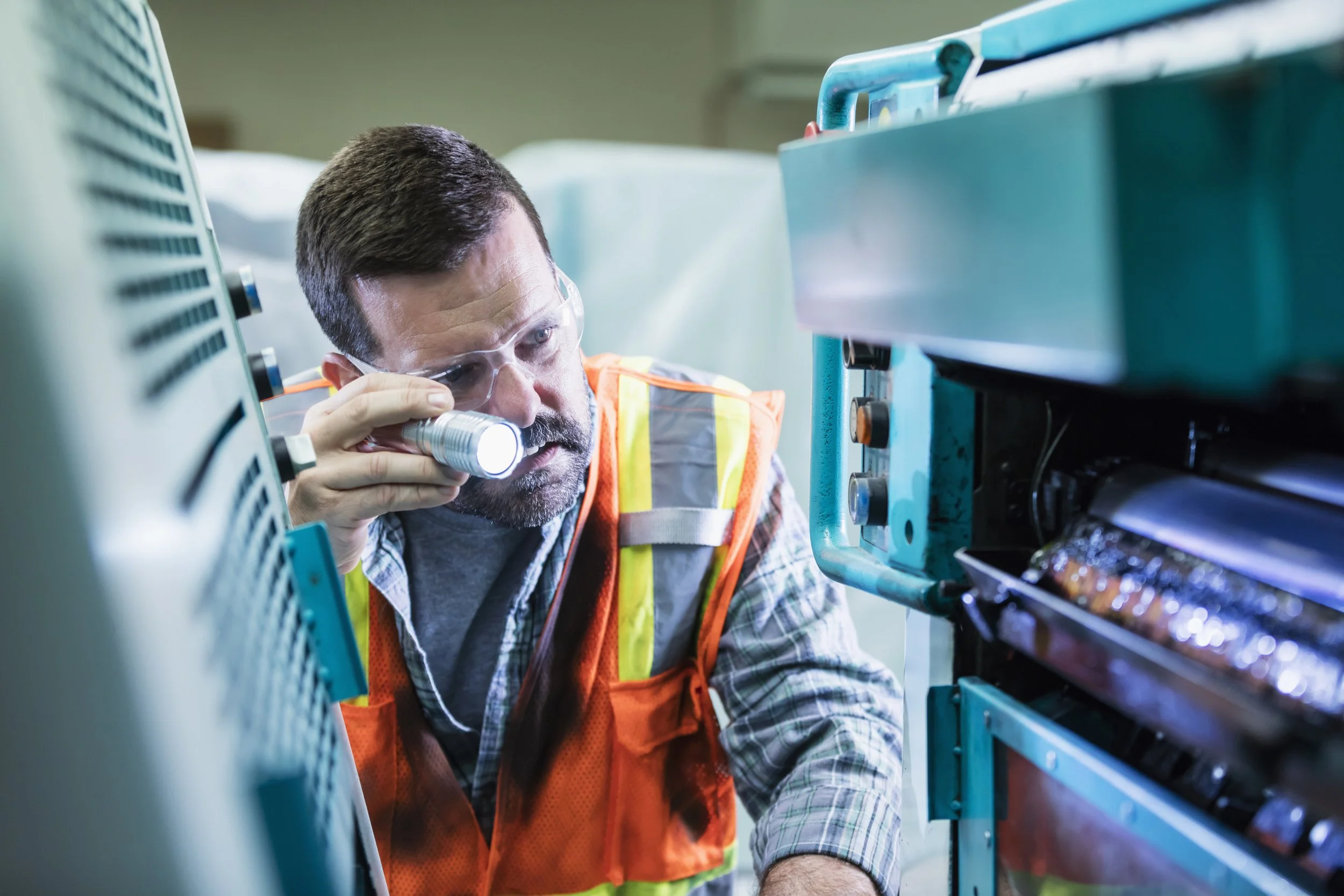 Image of service technician examining a printing press
