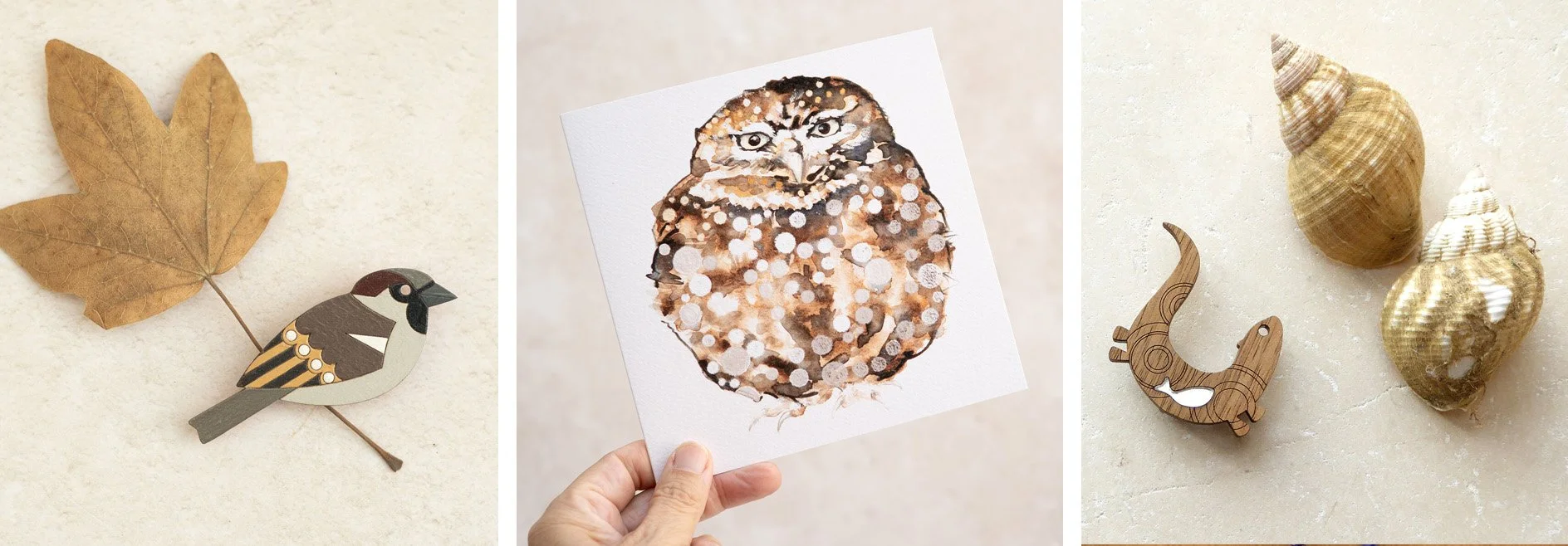A collage of three images: the first shows a brown maple leaf brooch with a small bird figure; the second displays a watercolor painting of an owl on a white paper; the third features a small wooden dinosaur figure surrounded by three sea shells on a neutral surface.