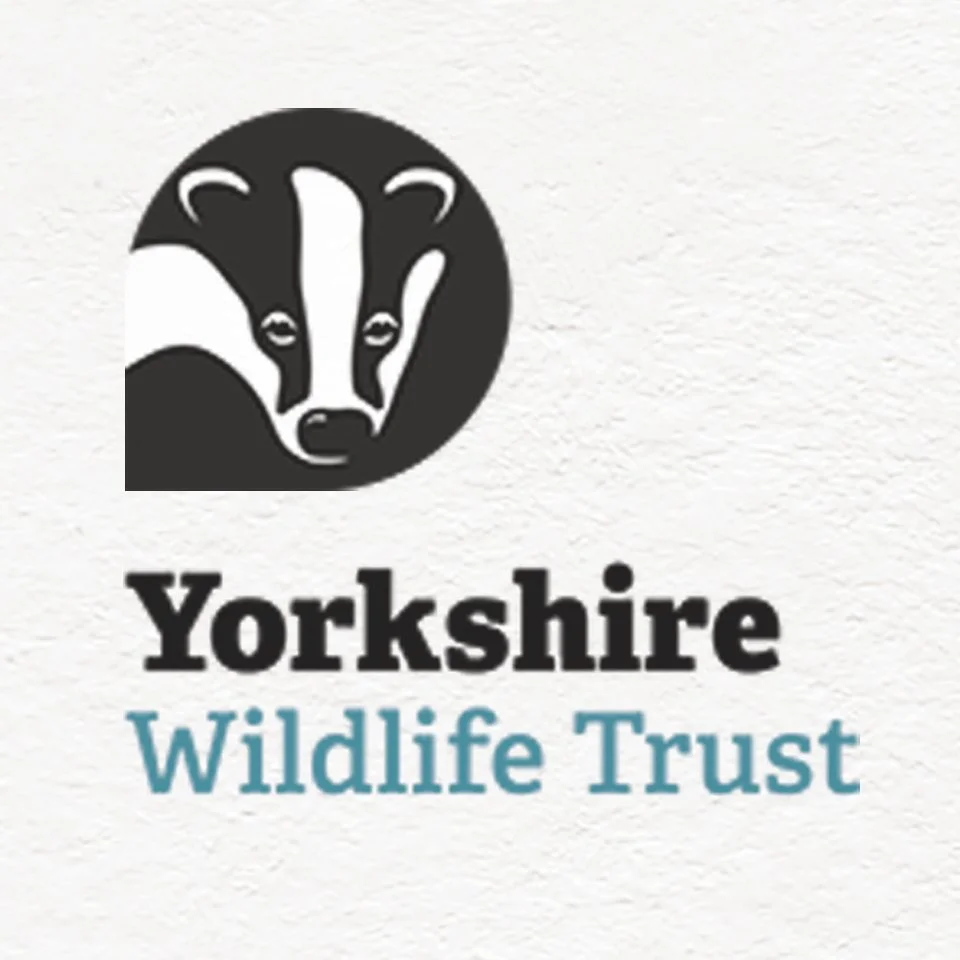Logo for Yorkshire Wildlife Trust featuring a stylized badger head in a black circle with black and white text.