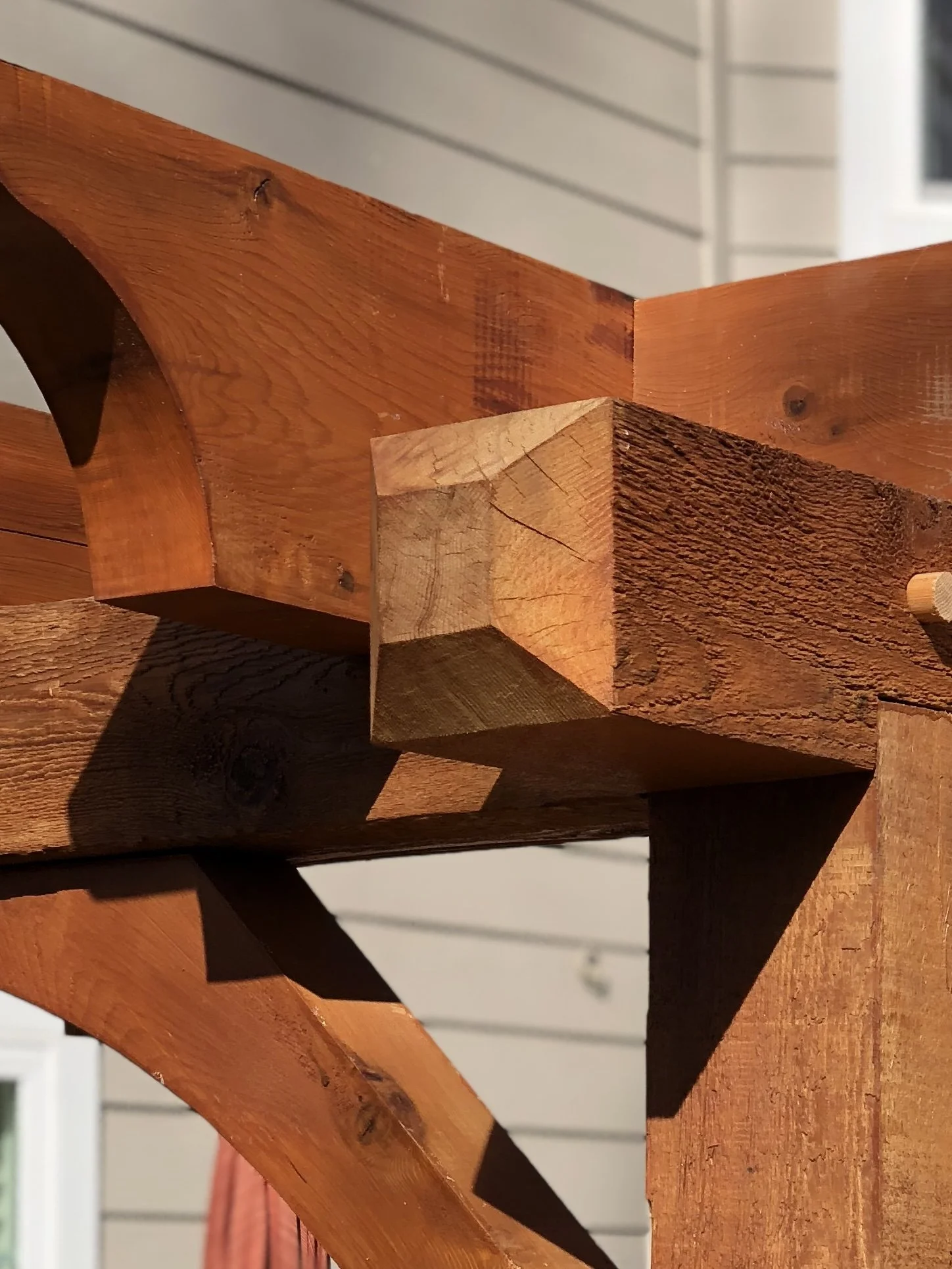 Close-up of wooden stairs with a reddish-brown finish, showing the grain and knot details.