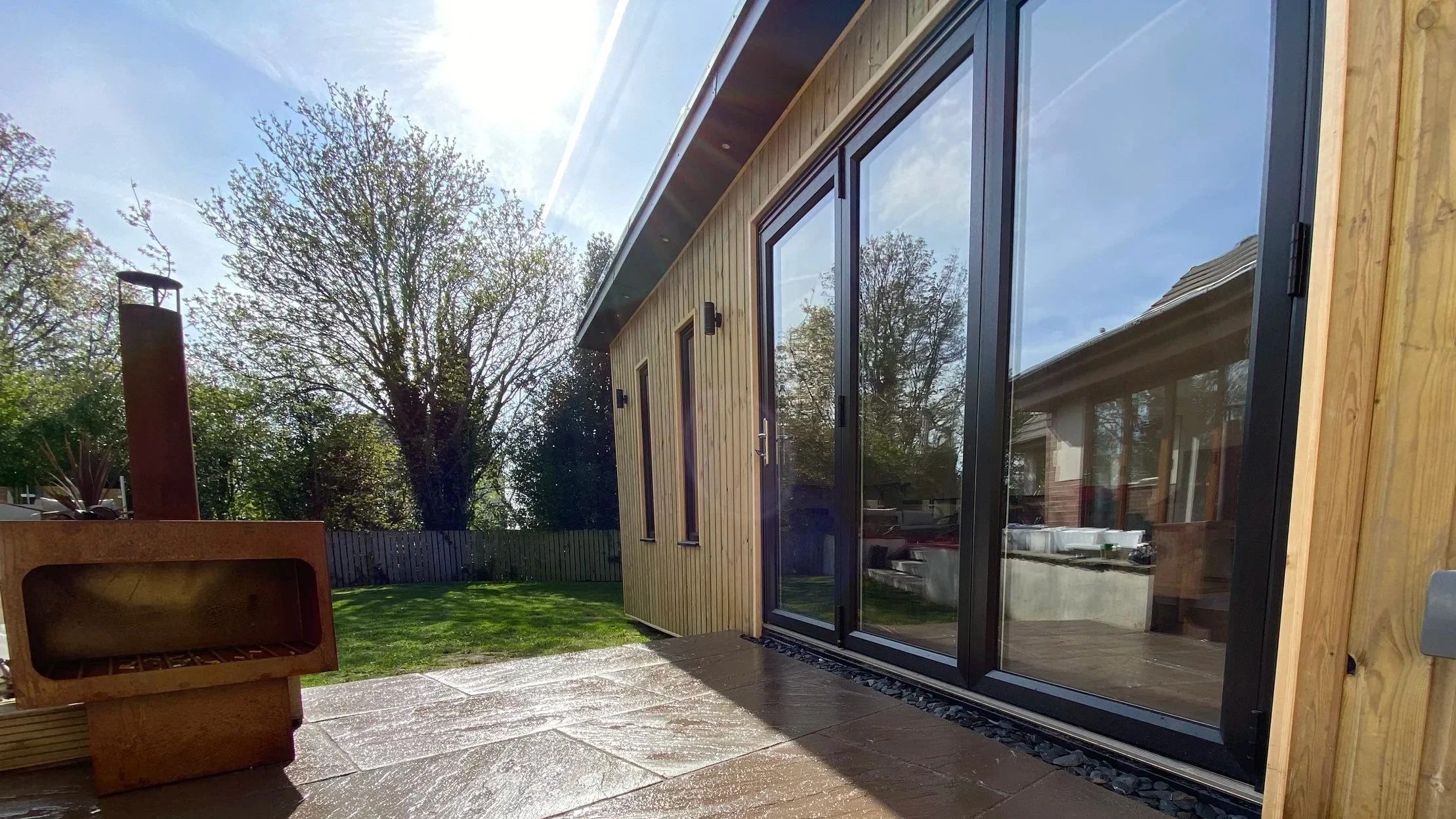 Modern bespoke garden room with large sliding doors overlooking the garden
