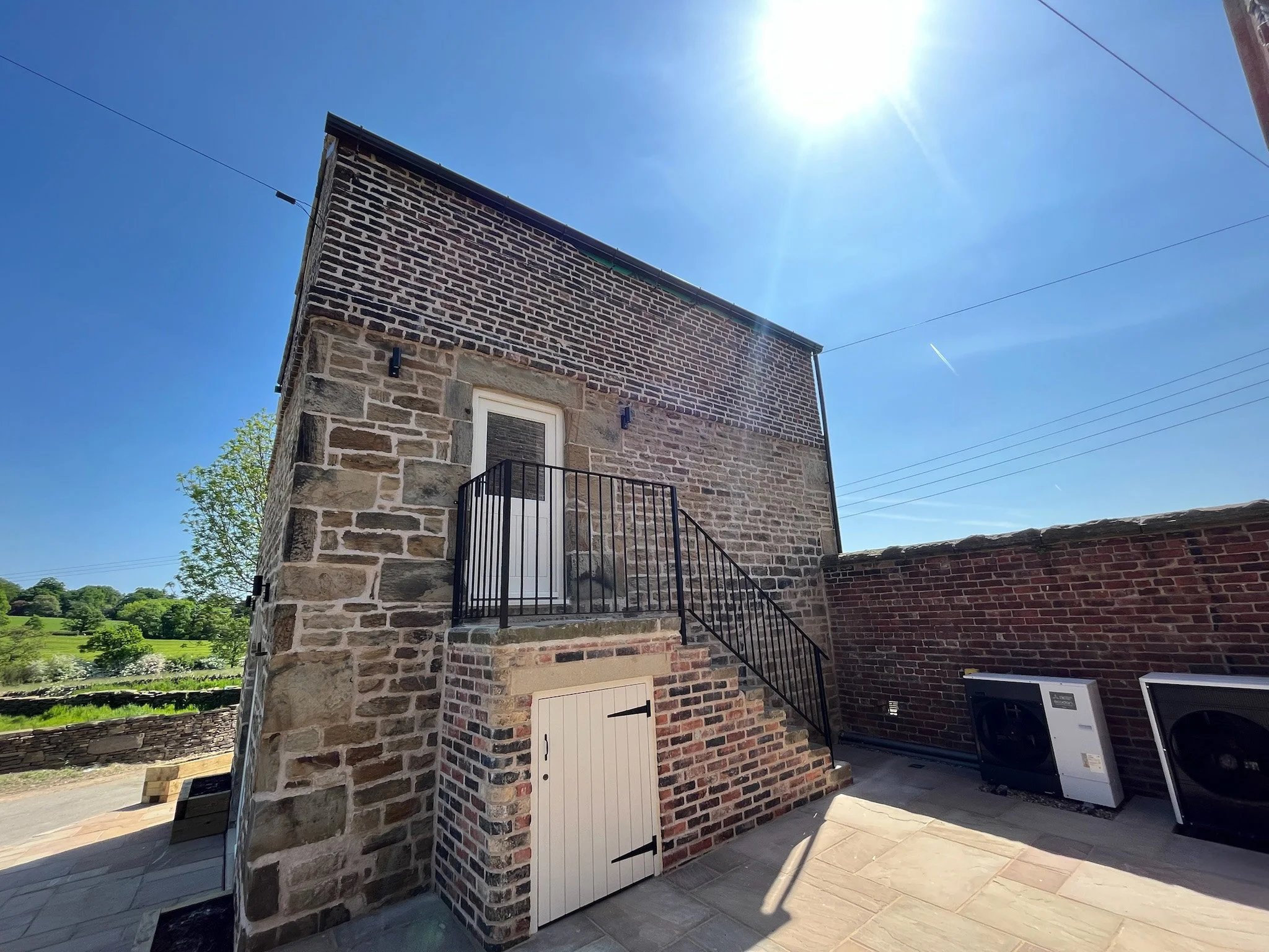 Side elevation of the completed barn conversion showing restored masonry and external staircase.