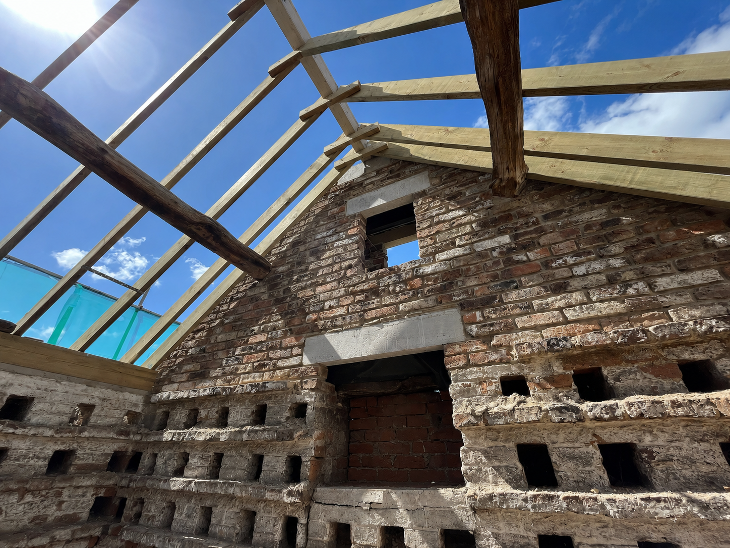 Heritage roof restoration showing original brickwork, timber roof construction and structural repair works.