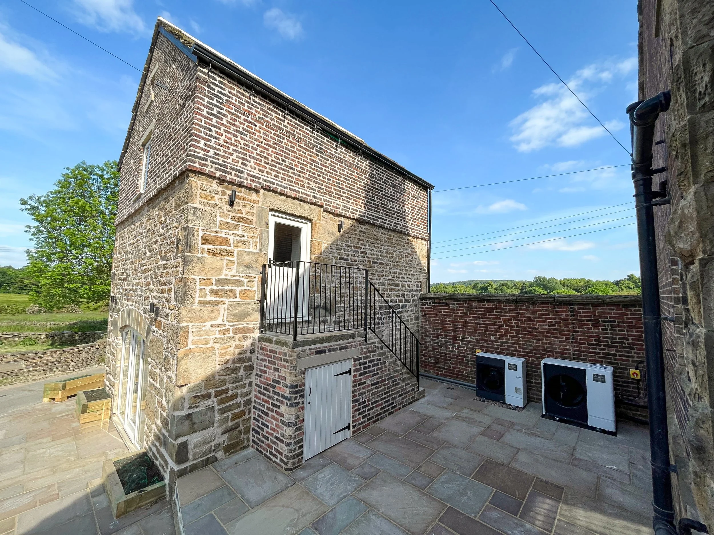 Side elevation of the completed barn conversion with restored stonework and traditional detailing.