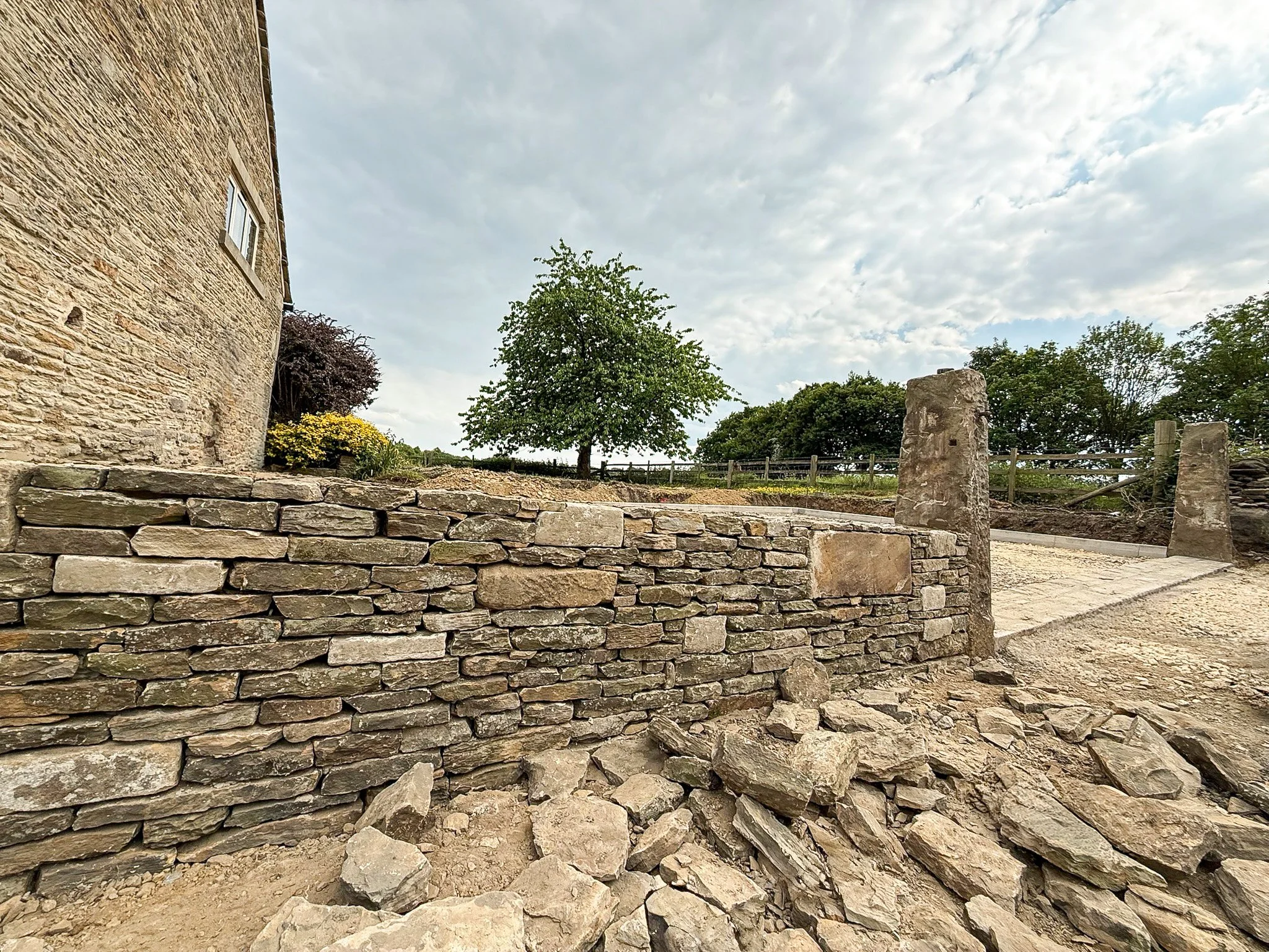 Traditional stone boundary wall rebuilt and restored as part of the external works.