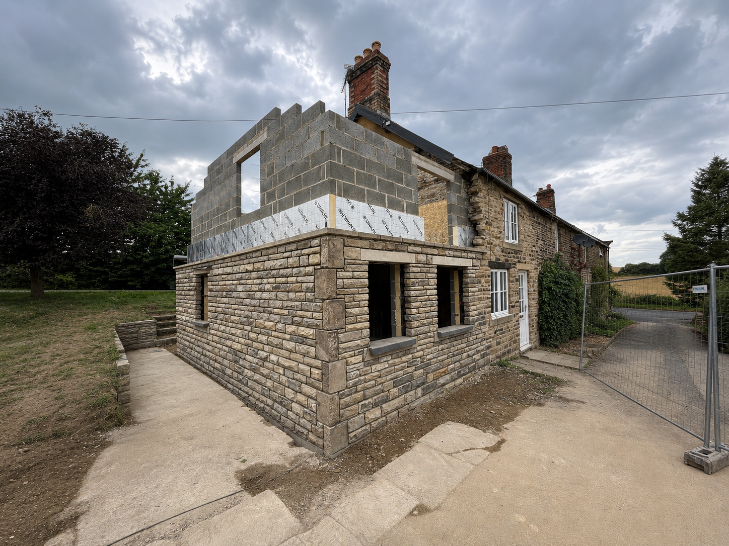 Double storey extension during construction showing new masonry and upper floor build.