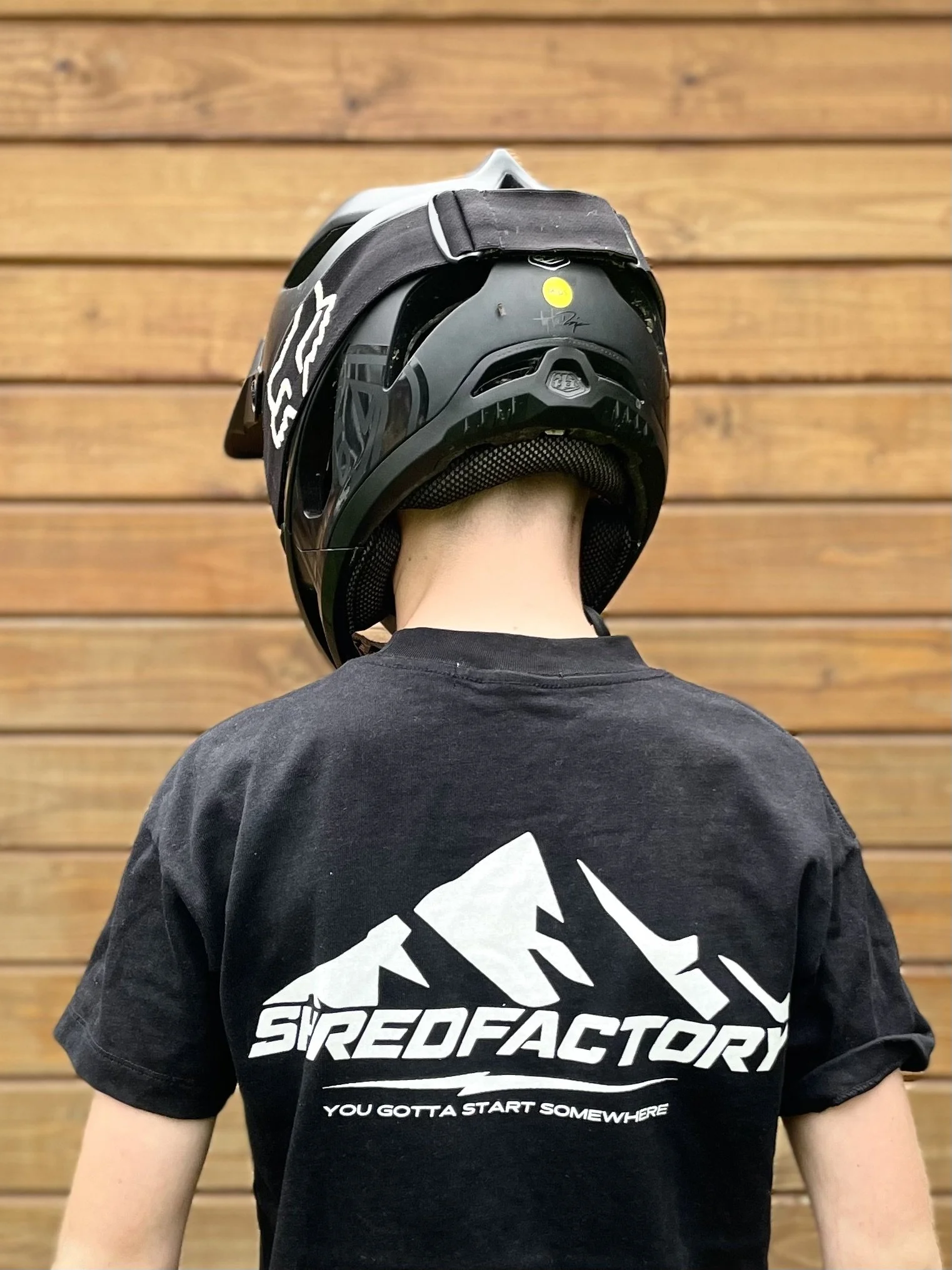 Boy wearing a full-face helmet and mountain biking t-shirt