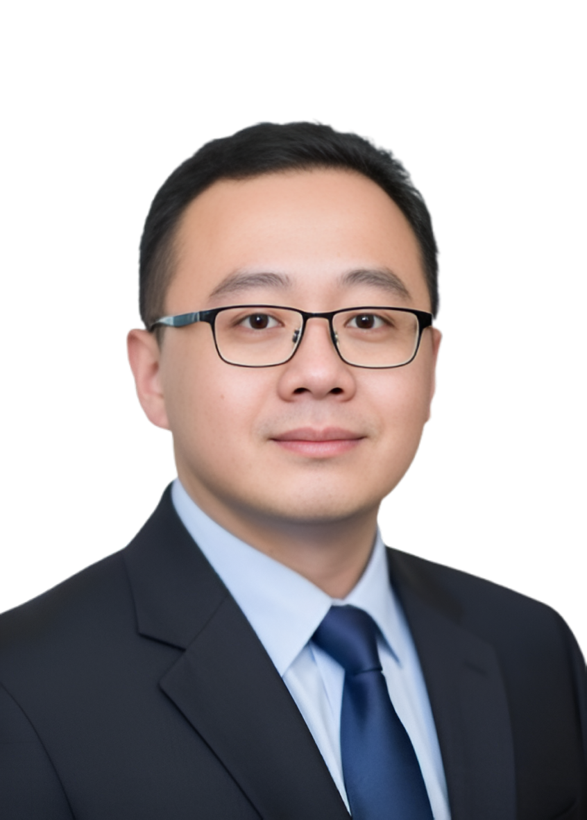 Professional headshot of a man wearing glasses, a dark suit, and a blue tie, with a plain background.
