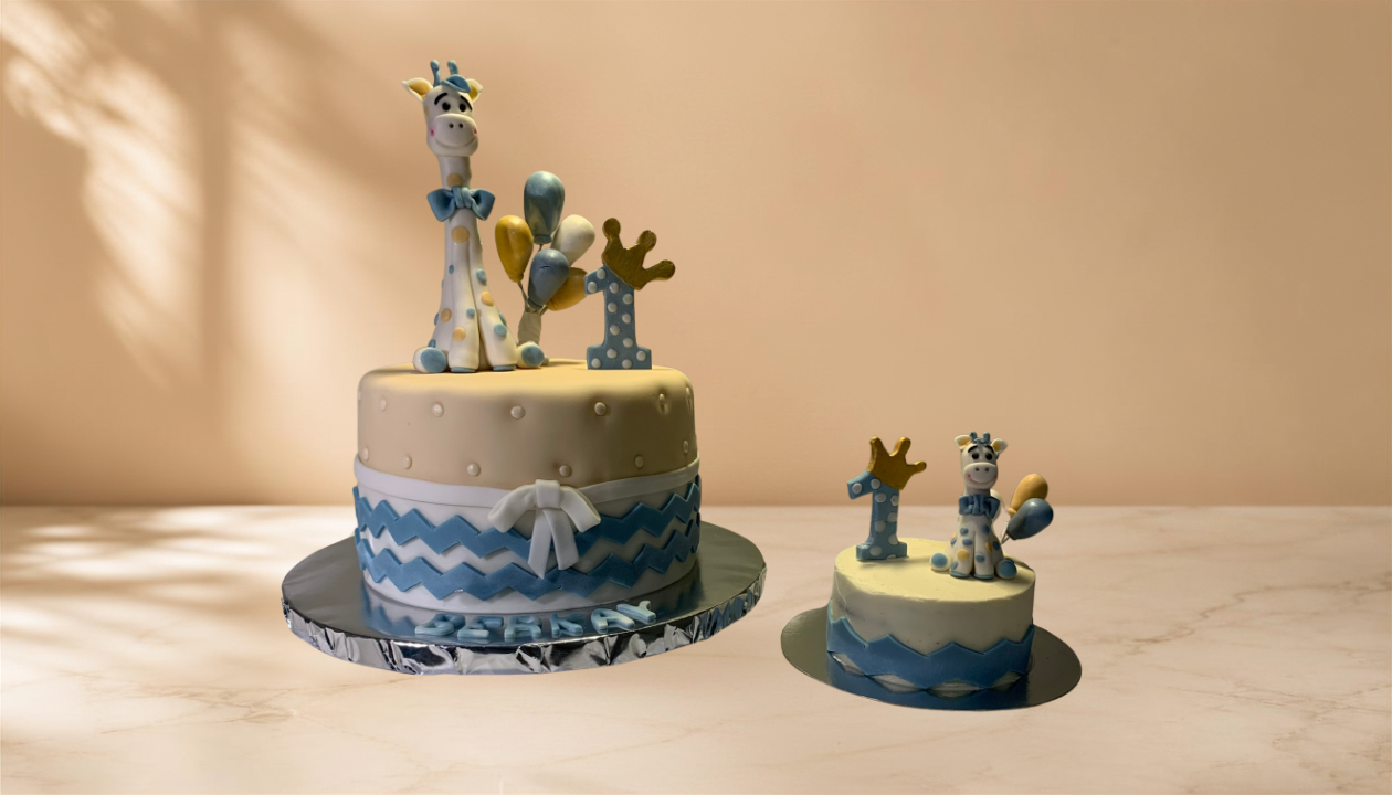 Two decorated birthday cakes with a cow and balloons, celebrating a first birthday.