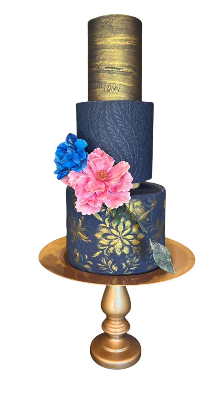 A three-tiered cake decorated with blue and pink flowers on a gold-colored stand