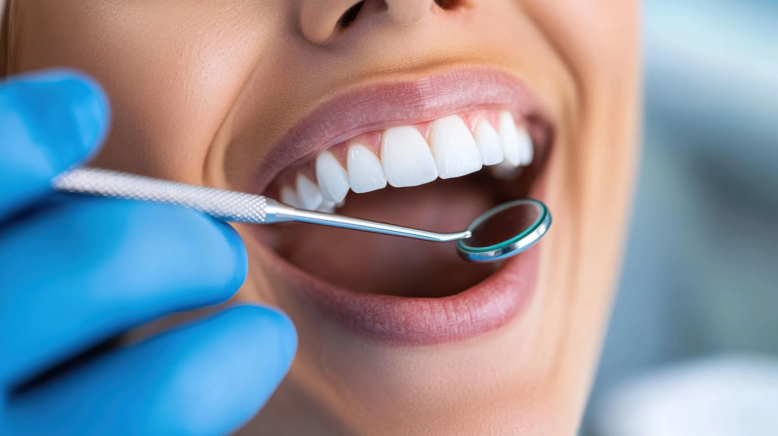 Dental professional examining patient's teeth with dental mirror.