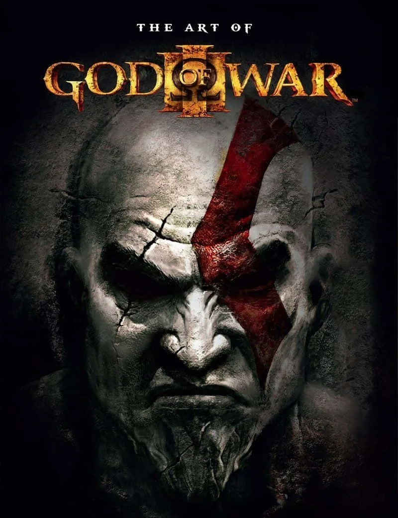 Cover of the video game 'God of War' featuring a close-up of a stern, cracked stone face with a red painted scar and the title 'The Art of God of War II' at the top.