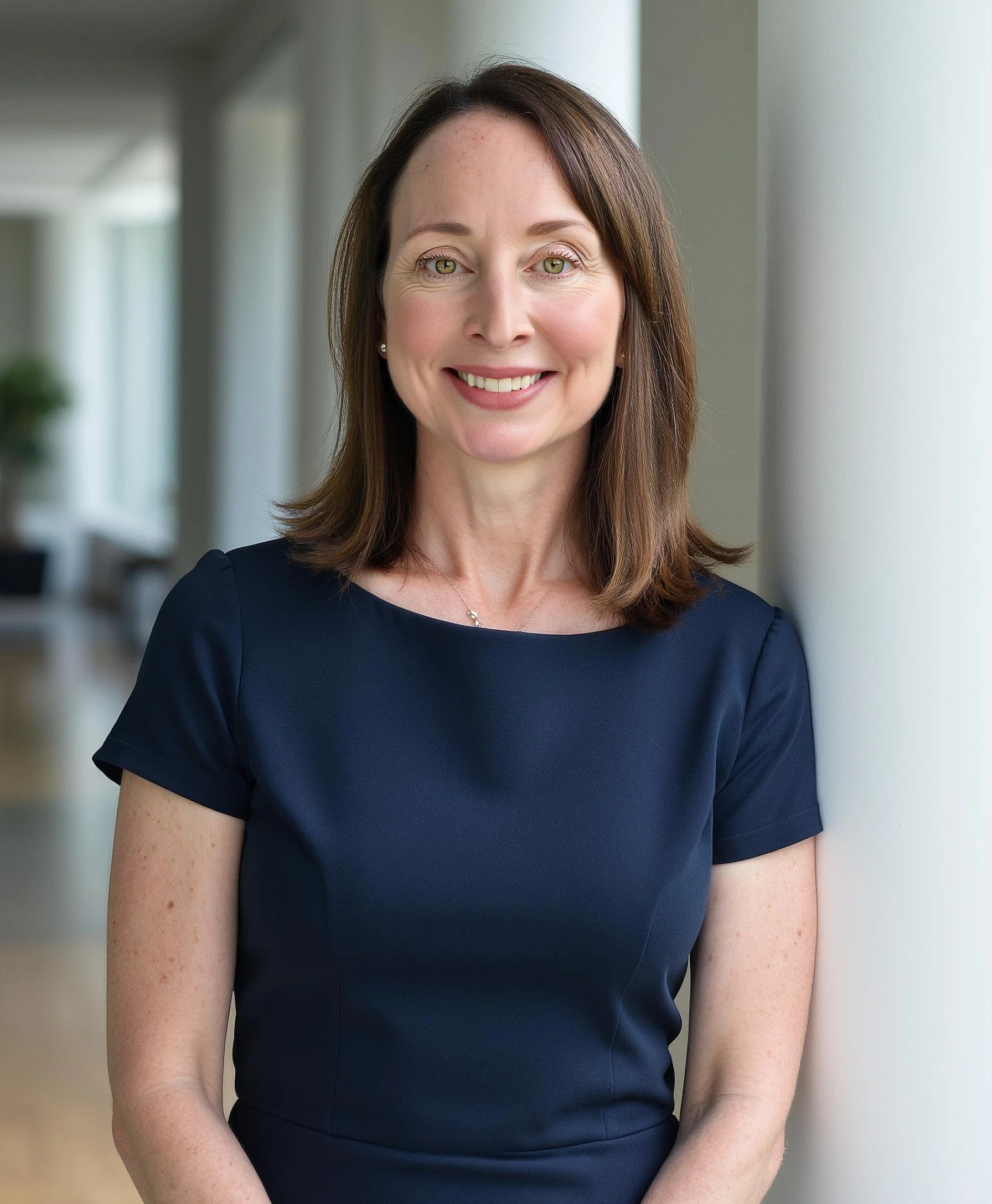 Kathleen standing indoors near a white wall