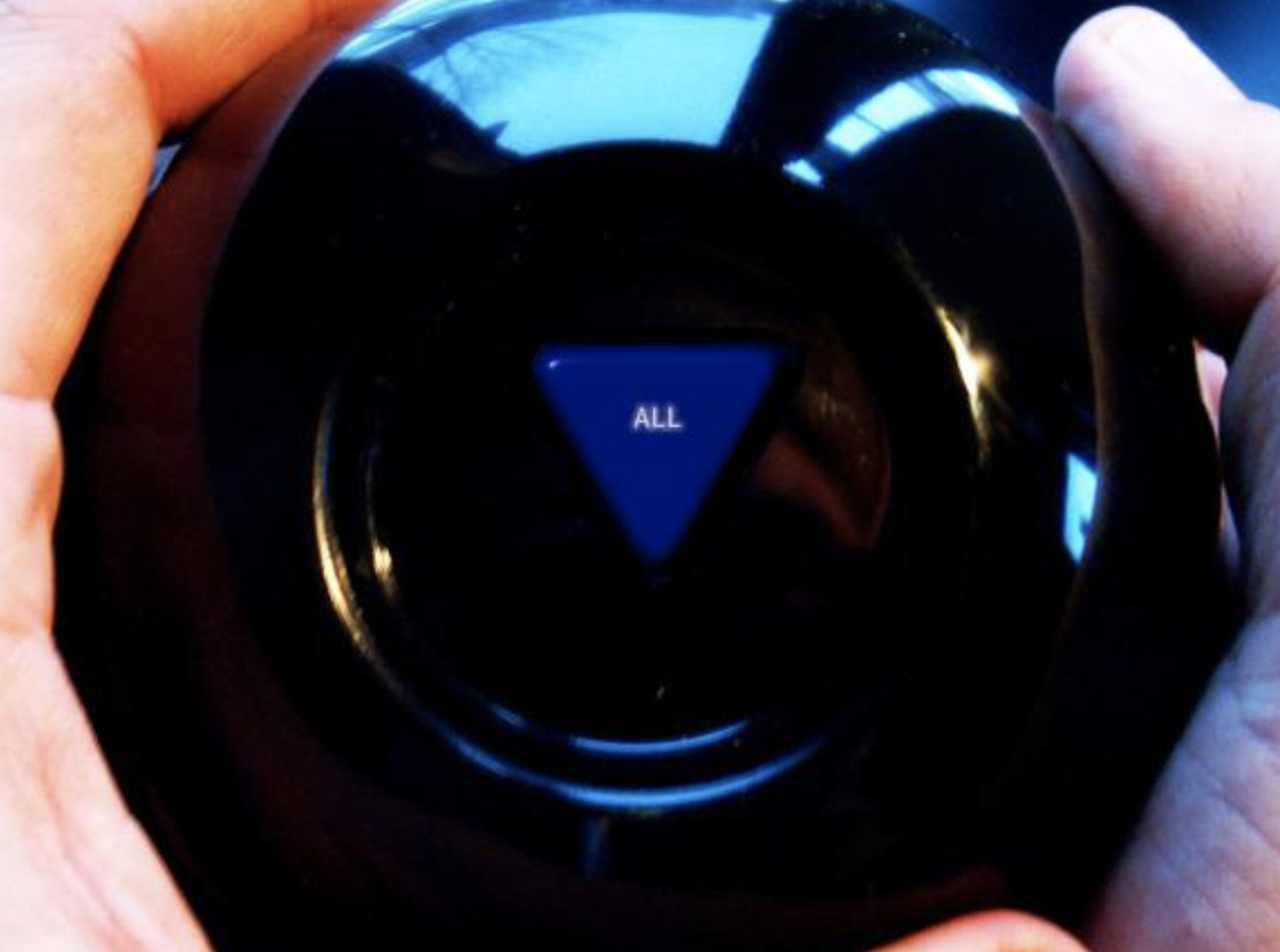 Close-up view of a car's climate control system showing a circular dial with a blue triangle button labeled 'ALL' in the center, surrounded by black reflective surfaces.