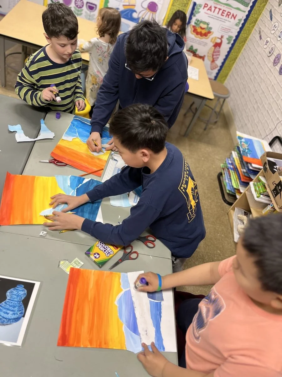 Bay Ridge Brooklyn children and an adult working on a sunset landscape using oil pastels at a classroom table.