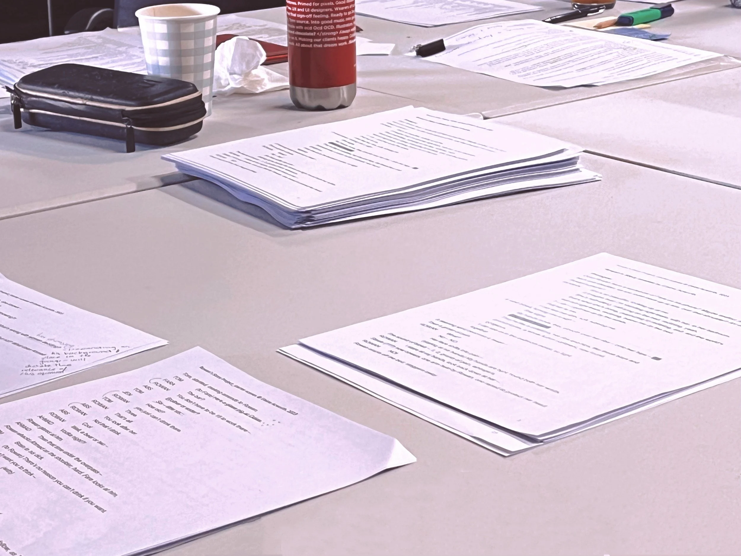 Scripts and writing materials arranged on a table, representing Cassie Xue’s creative writing and playwriting work.