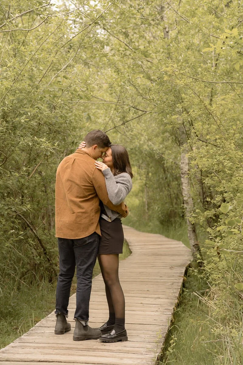 Couples photographer in Olympia WA - couple standing on boardwalk touching noses surrounded by nature - Angela Rivers Photography