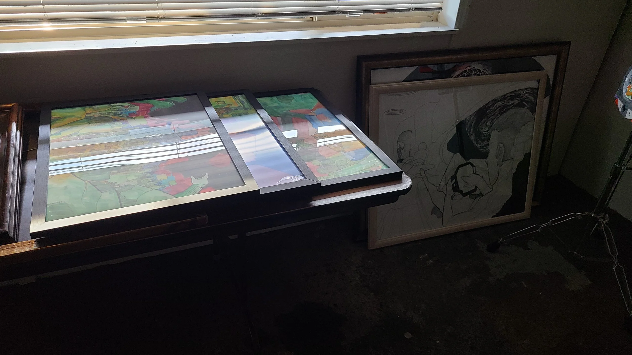 A collection of framed work by Jon Hwong