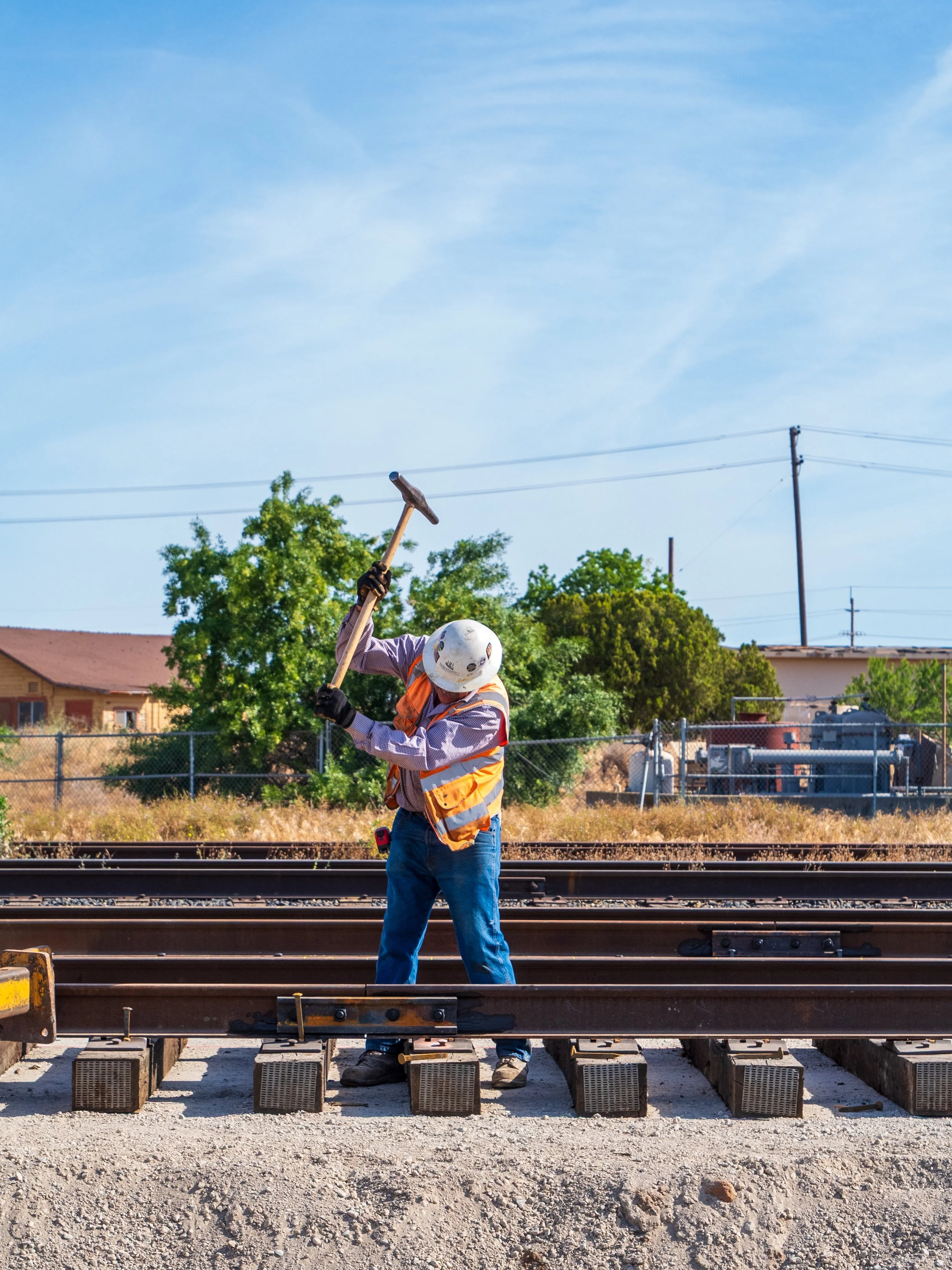 Construction worker using a sledgehammer on a railroad