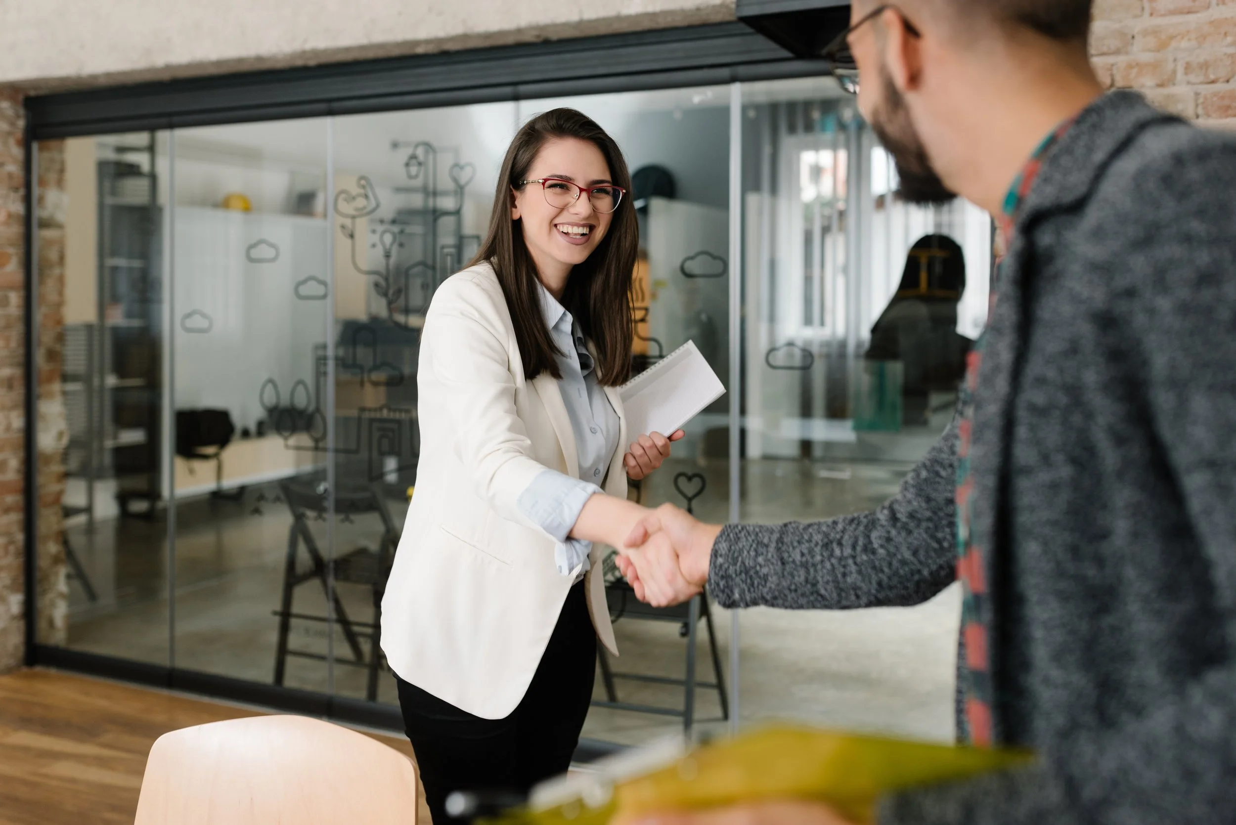 Young woman shaking hands with another person in professional attire