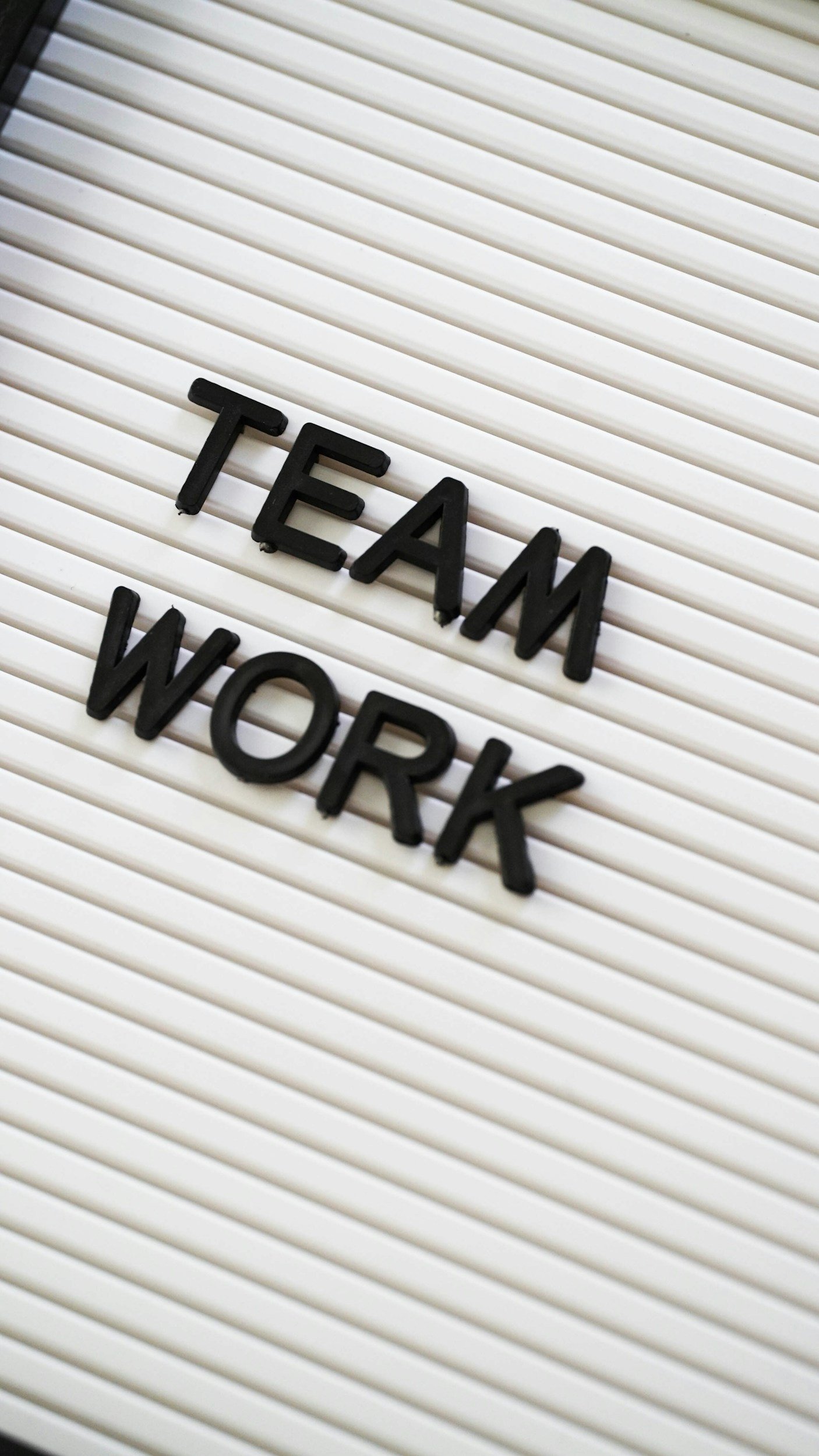 Letter board displaying the words TEAMWORK, representing collaboration and organizational effectiveness.