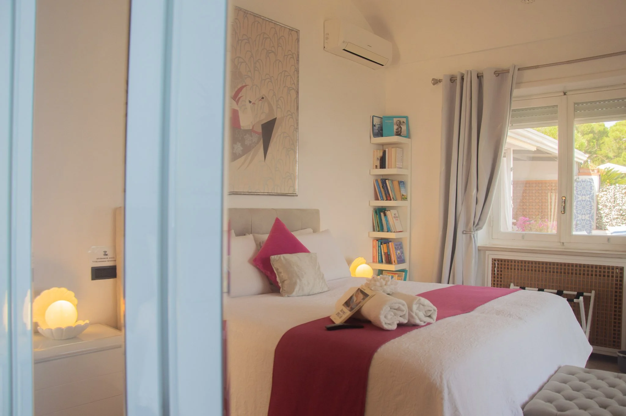 Master bedroom viewed through an elegant gold-pink tinted mirror wardrobe at a Capri holiday rental.